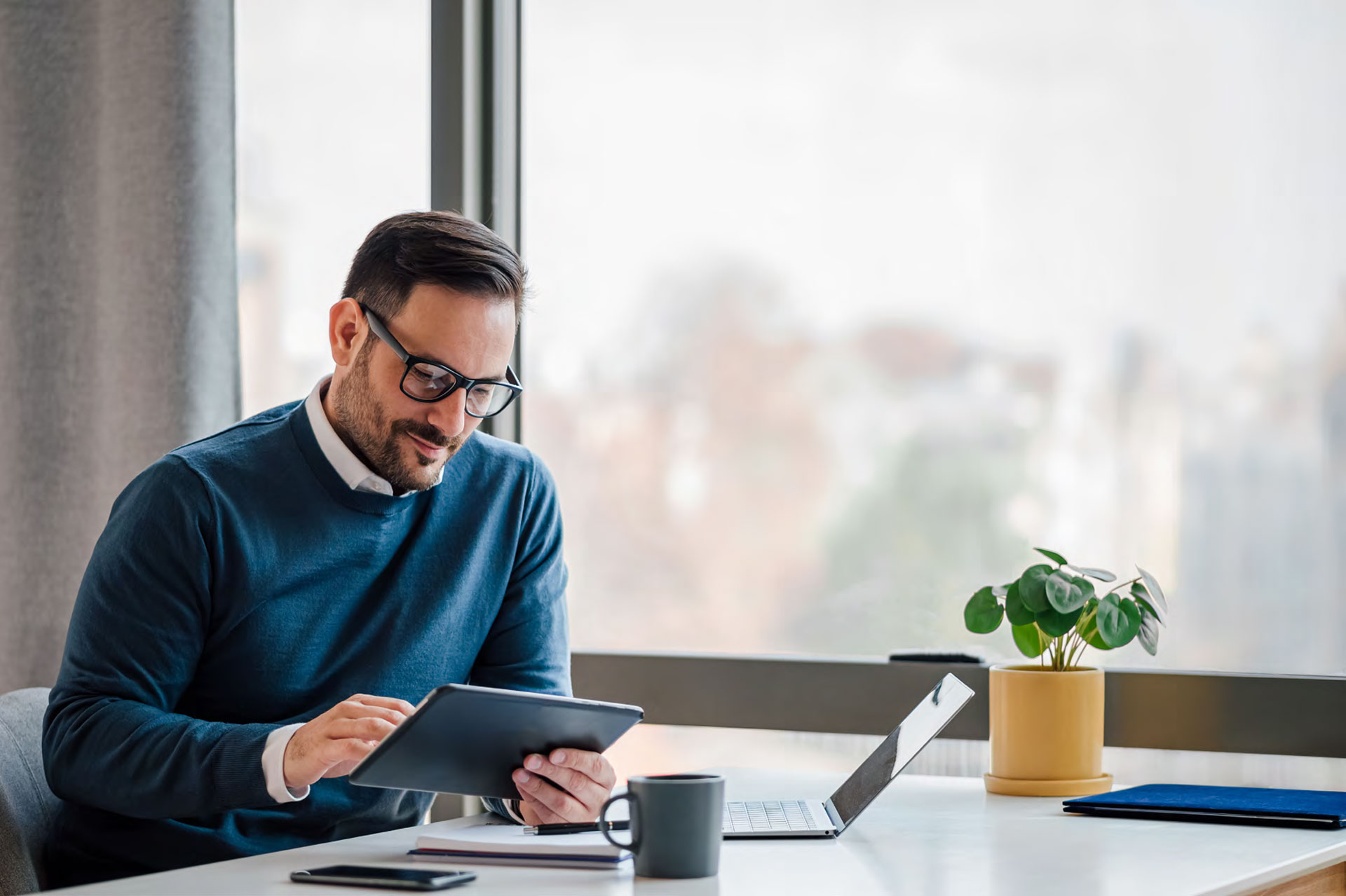 man in an office holding a touchpad